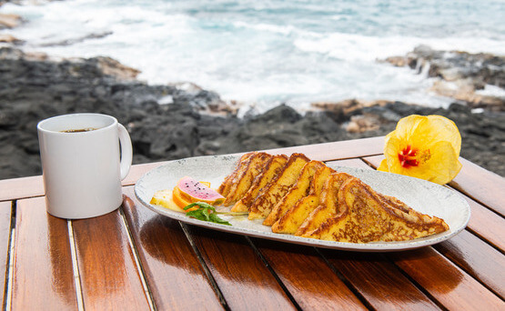 French toast breakfast served with coffee on table with ocean view 