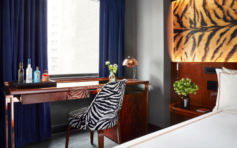 zebra stamp chair behind a desk with a window by bed