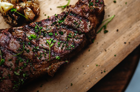 grilled steak on a wooden platter