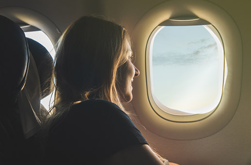 woman starring out the window of a plane