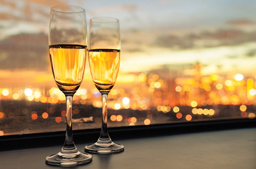 two champagne glasses against the ny skyline