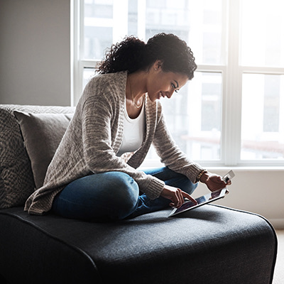 woman sitting on a chair holding a tablet