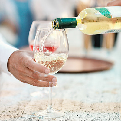 closeup view of someone filling glasses of white wine
