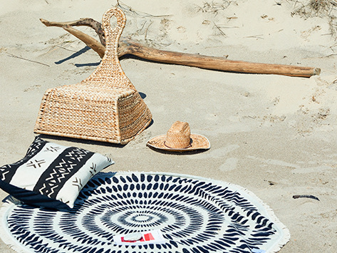 beach hat, chair and blanket on sand