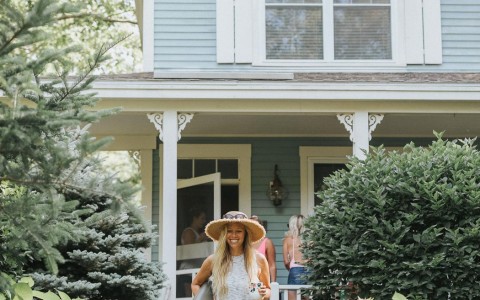 woman walking out from a cottage and smiling