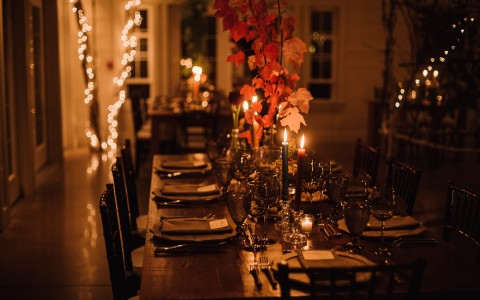 dining setup in restaurant with dim lighting and candles on the tables