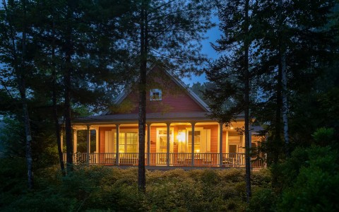 exterior of accommodation amidst the trees with a porch light on