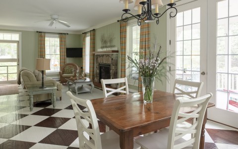 table for four inside cottage with an open floorplan leading to the living room with a fireplace