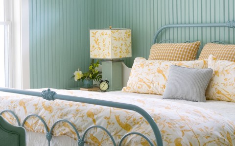 bed with white and yellow bedding in a light blue colored room