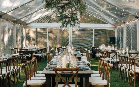 tent set up outside with tables underneath for a wedding reception