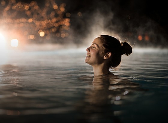 women relaxing in the pool at night
