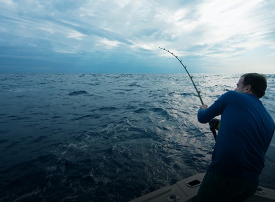person on the water deep sea fishing with their line cast in the water