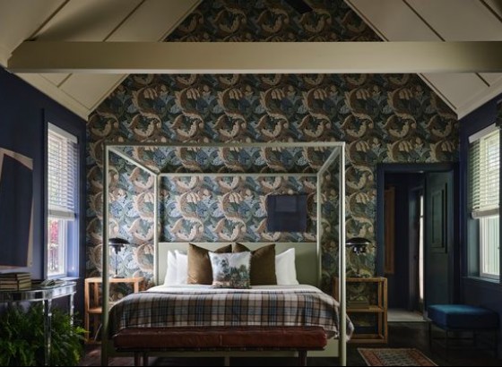 mountain side cabin featuring bedside featuring a swirl leaf print wallpaper