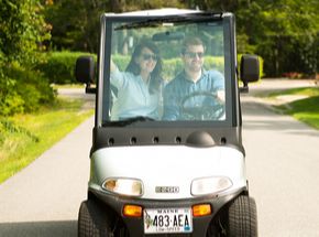 couple driving in a golf cart together