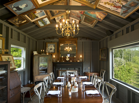 painting shed set up for private dining with paintings hanging on the ceiling 