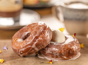 wooden board with two glazed donuts