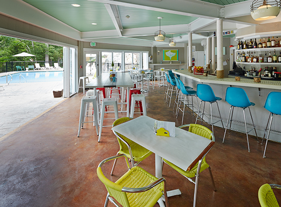 outdoor dining space with a bar leading towards a pool