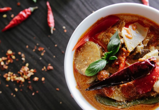 bowl of tortilla soup next to chilies