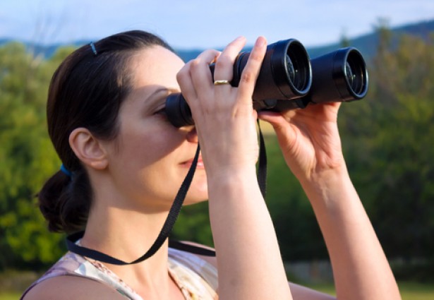a woman looking at the scenery with binoculars