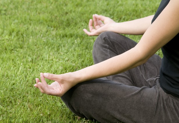 a person meditating in the grass