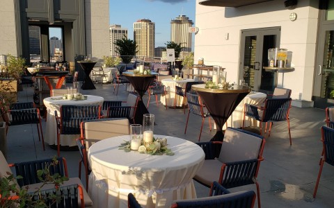 terrace with tables and blue chairs with wedding decor 