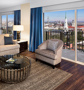 Suite living room with seating area and balcony that over looks the city