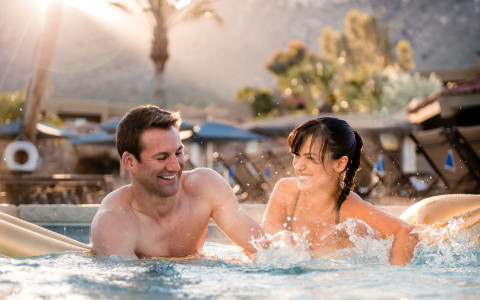couple splashing in pool