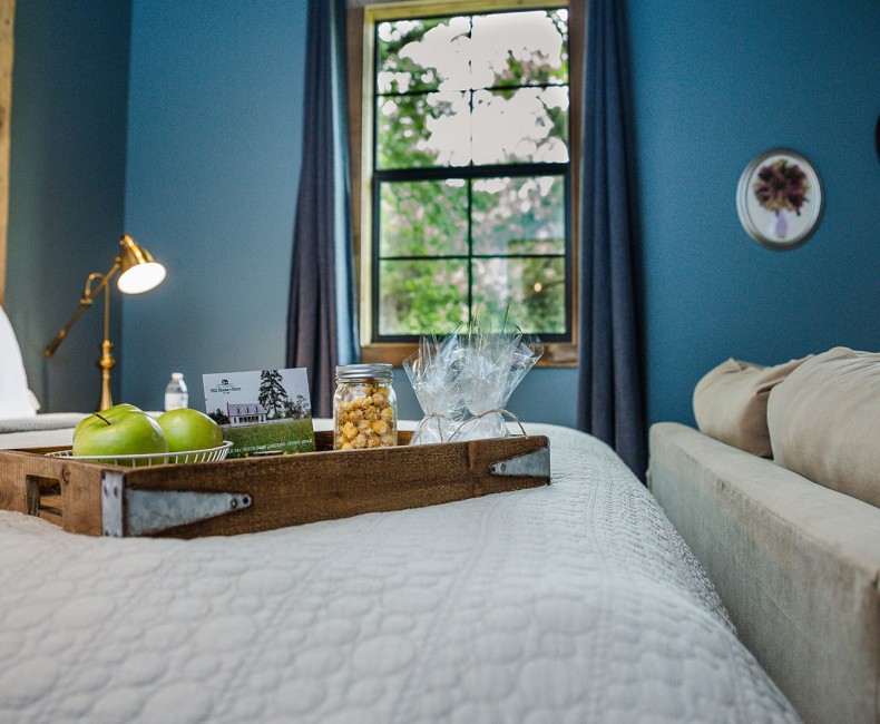 tray filled with an assortment of goods on top of the bed