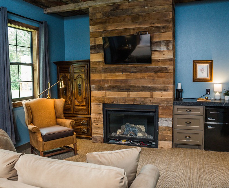 view of fireplace with tv over top with mini and storage and lounge chair on other side