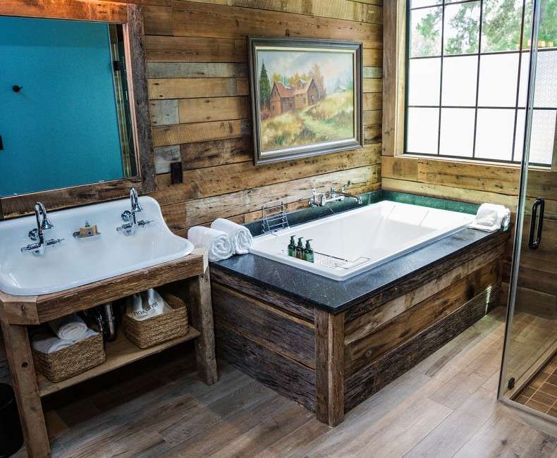 view of wooden bathroom with double sinks, bathtub and walk in shower
