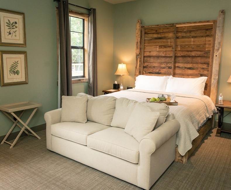 queen bed with wooden frame and pull out couch in front