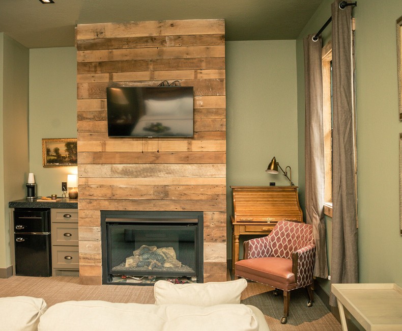 view of fireplace with tv overhead and mini fridge and storage