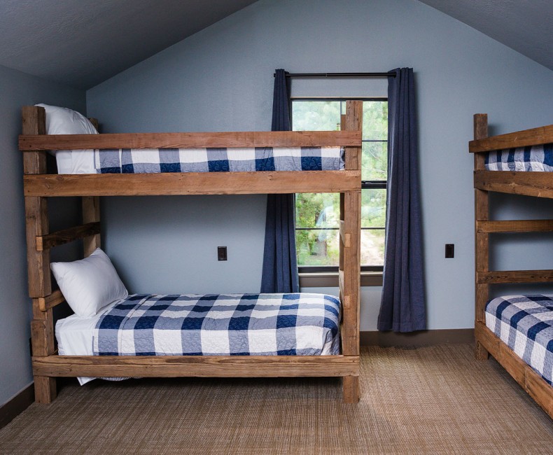 two sets of wooden bunk beds with grey and white bedding