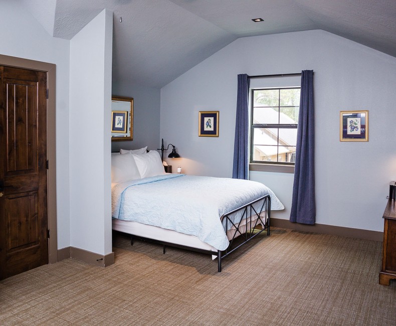 view of a blue room with a queen bed and tv and window by