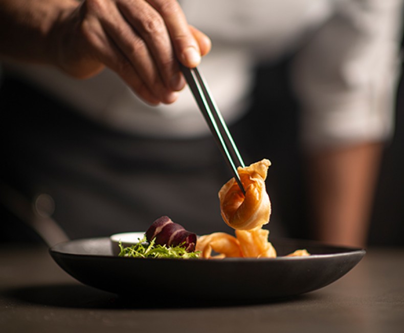 man picking up shrimp wontons with chopsticks