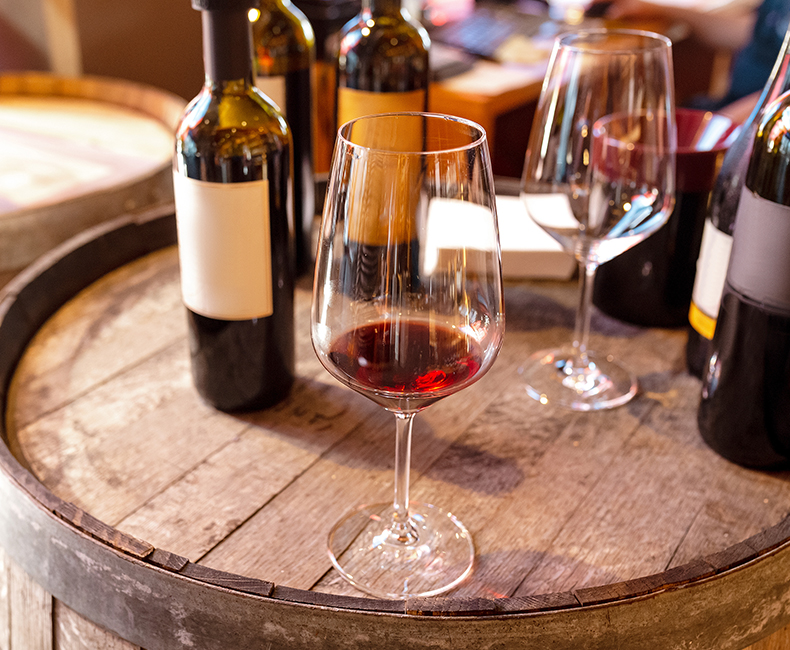wine bottles and glasses on a oak barrel