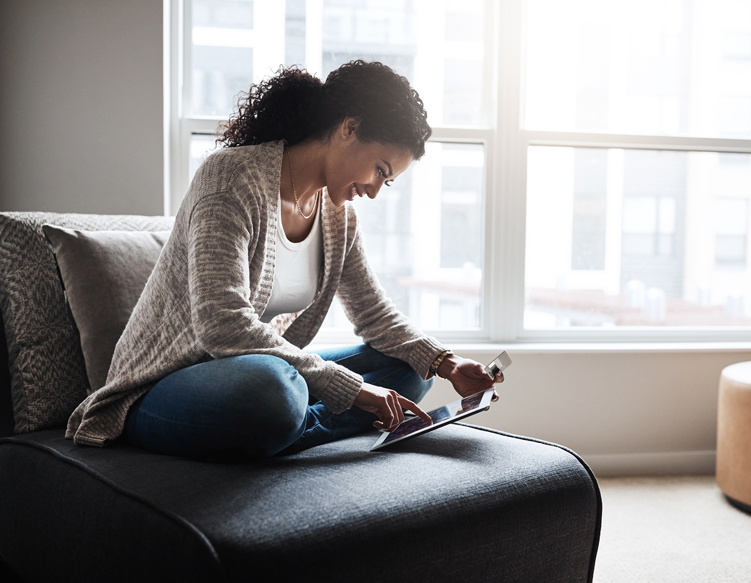 african american woman holding an ipad and a credit card