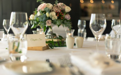 a table setup for dining with a floral centerpiece in the middle