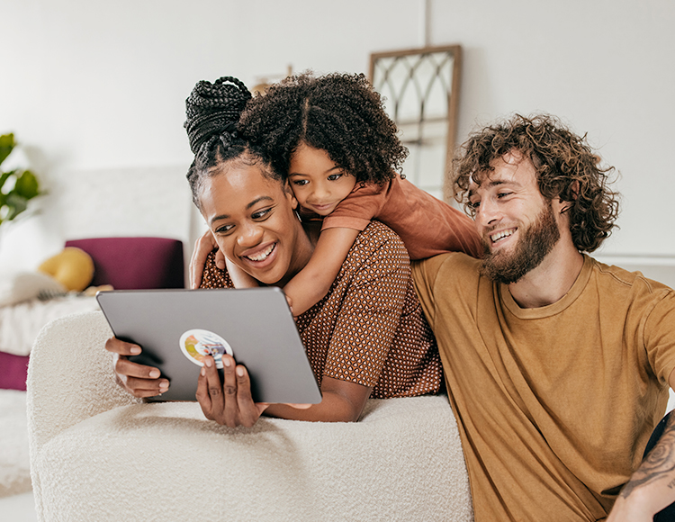 a smiling family looking at a tablet