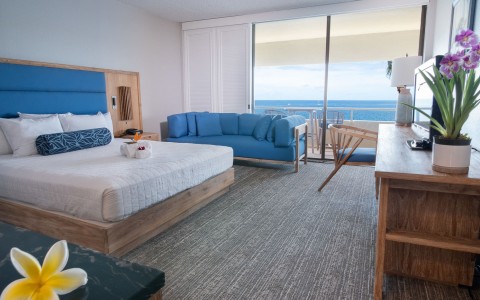 suite hotel room with a private balcony in blue accents