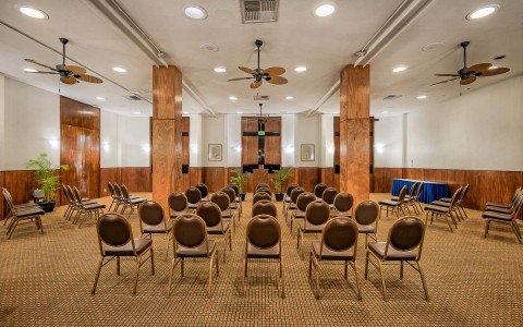 A big meeting room full of brown chairs and elegant decoration