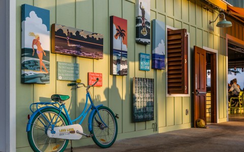 A facade full of sea paintings and a blue bicycle standing on the wall