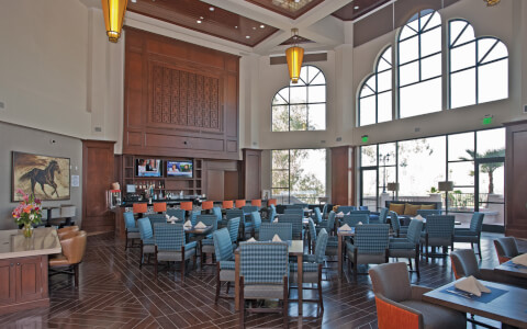 resteraunt with an assortment of seating and high ceilings with wide view windows