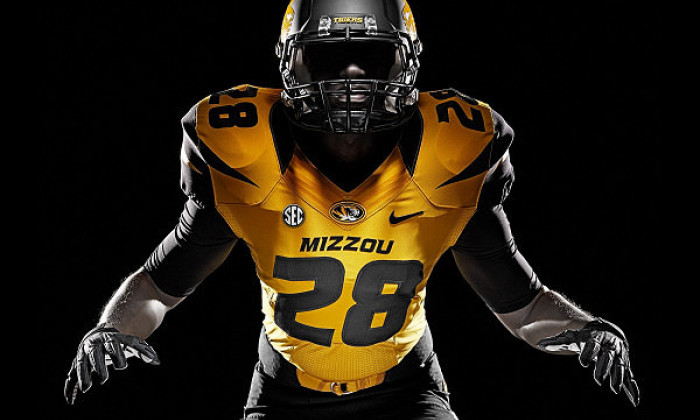 MIZZOU football player in gold jersey number 28 against a black background