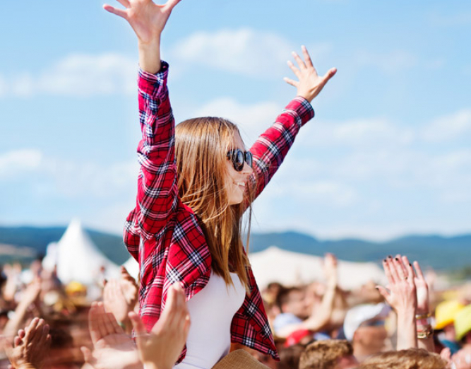 Woman sitting on man's shoulders at concert