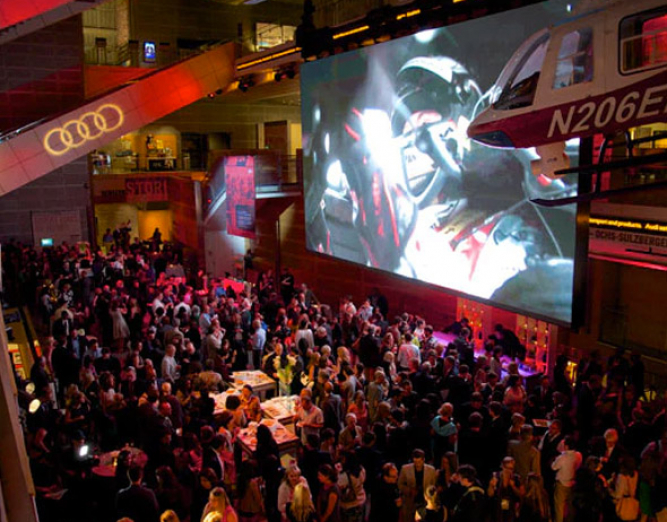 Aerial view of room with crowd & large screen