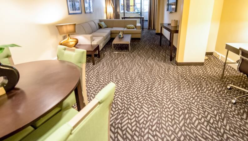 Hotel room with a desk, table and chairs, and an L shaped couch