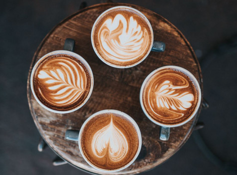 four cups of coffee with latte art