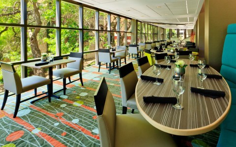 hotel restaurant with large windows and green and blue decor