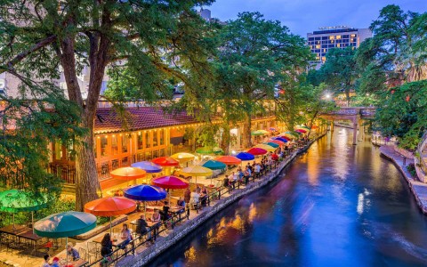 overhead view of the San Antonio riverwalk lined with colorful umbrellas